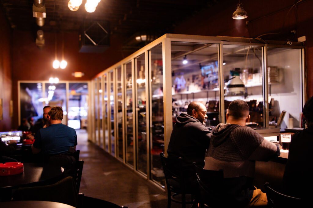 Guests seated beside the long glass humidor at Classic Cigars