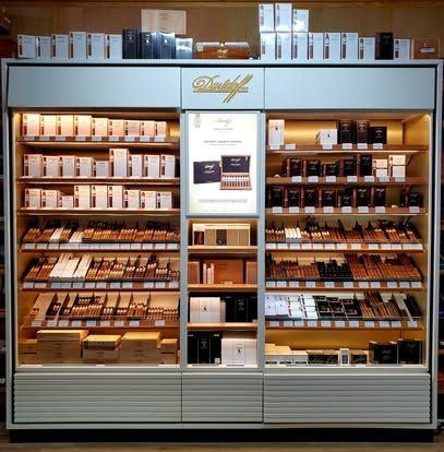 Lit Davidoff display cabinet at Fogue & Bates stocked with cigar boxes and packs